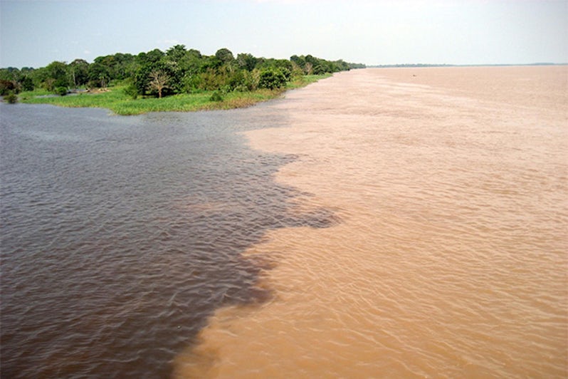 Meeting of the Rio Amaturá (black water) and the Rio Solimoes (muddy water) at Amaturá in the Amazon, Brazil