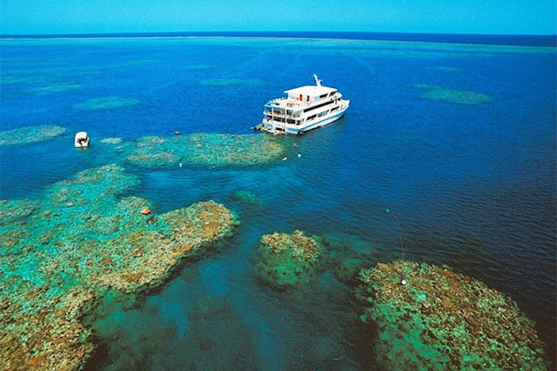 Aerial shot of Coral Expeditions ship cruising the Great Barrier Reef