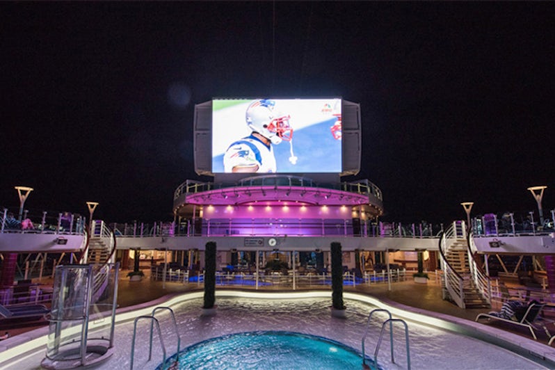 Outdoor movie screen overlooking pool on a cruise ship at night