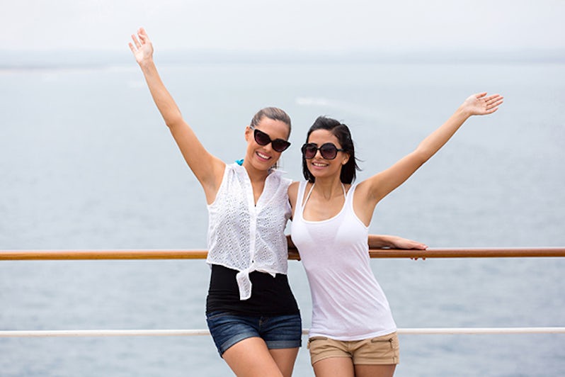 Two girls waving their arms on cruise ship