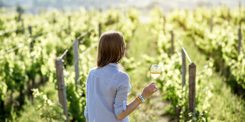 Woman Drinking Wine Observing Vineyard (Photo: RossHelen/Shutterstock)