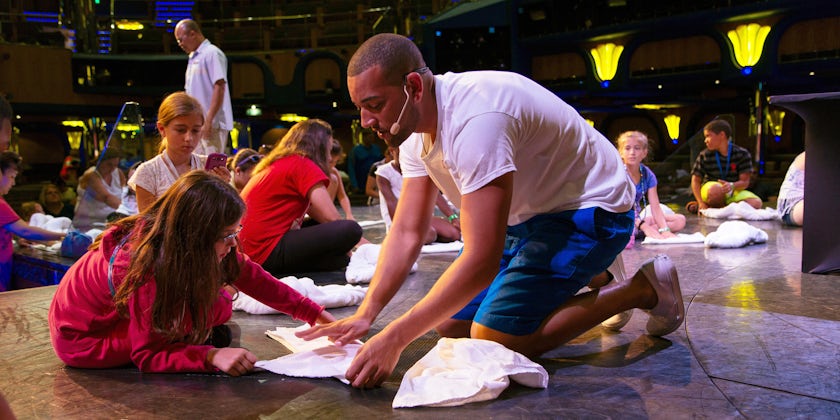 Cruise Director Teaching Children How to Create Towel Animals at the Towel Animal Theater (Photo: Carnival)