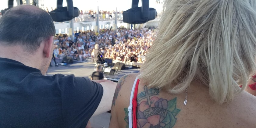 Photo of a blonde woman with a faded Bon Jovi tattoo on her left shoulder blade