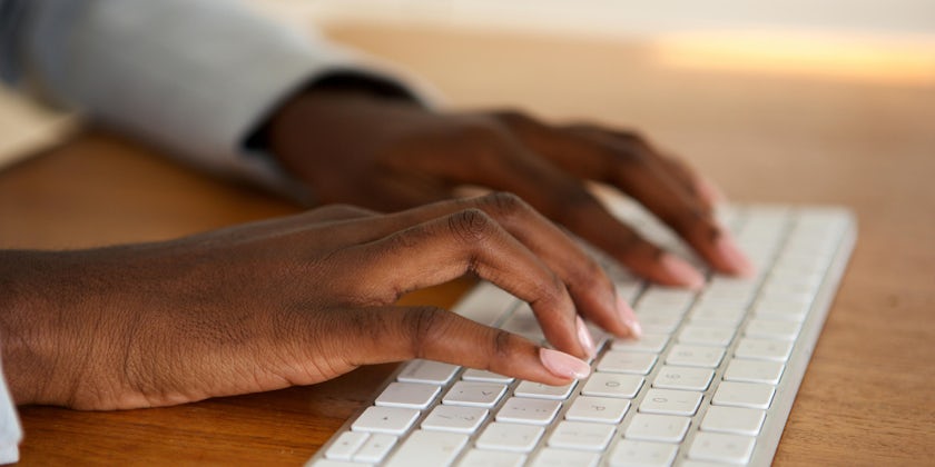 Close-up shot of black woman typing on a computer keyboard