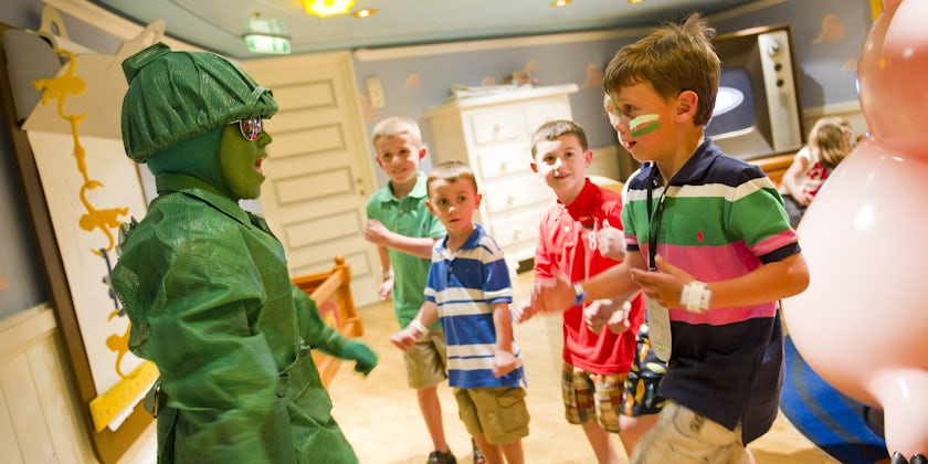 Group of kids interacting with an actor dressed as a toy soldier in Andy's Room, a Toy Story-theme room on Disney Cruise Line