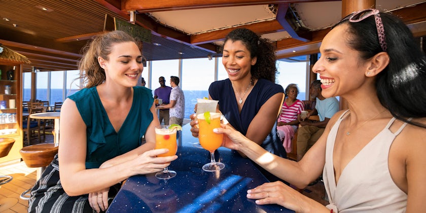 Three young women drinking and laughing on a cruise (Photo: Carnival Cruise Line)