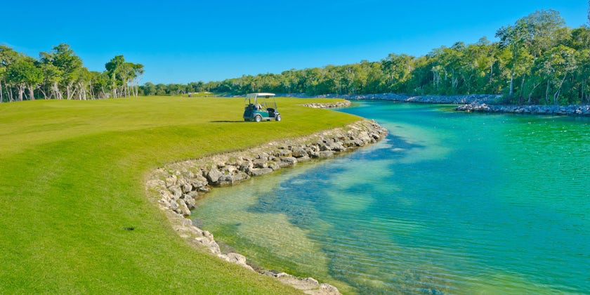 Lake at the beautiful golf course with the cart at the back on a Mexican resort (Photo: romakoma/Shutterstock)