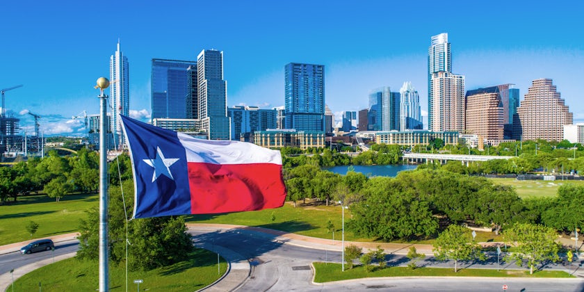 The Texas flag in view with the skyline of Austin in the background (Photo: Roschetzky Photography/Shutterstock)