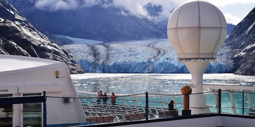 View of a glacier from a cruise ship, as passengers look out at an icy landscape