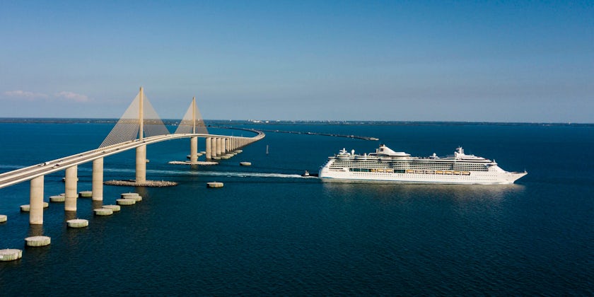 Aerial shot of a cruise ship sailing under the Sunshine Skyway Bridge in Tampa
