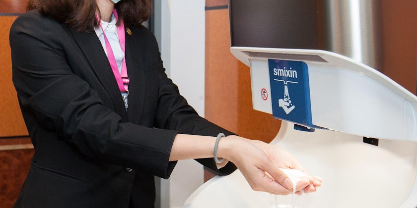 Woman using the automatic hand-washing station on Explorer Dream