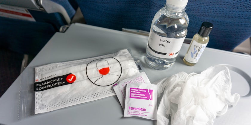 Close-up shot of the contents of Air Canada's COVID-19 amenity kit, laid out on the plane tray table