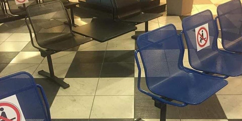 Social distancing signs on seats in the Genoa cruise terminal