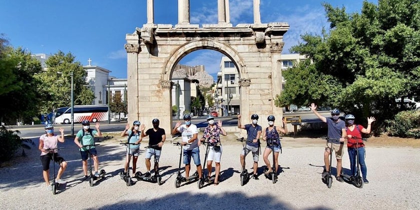Group of passengers wearing masks and waving on an e-scooter tour in Athens