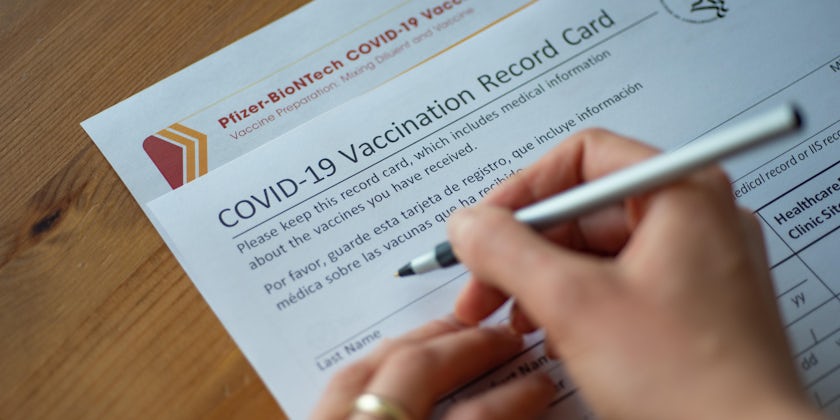 Close-up shot of a woman filling out The COVID-19 Vaccination Record Card and Pfizer-BioNTech COVID-19 Vaccine form