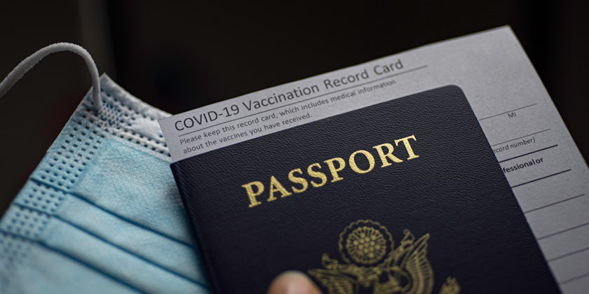 Blurred COVID-19 Vaccination Record card, Passport of USA and Medical Mask. Immune passport or certificate for travel concept.