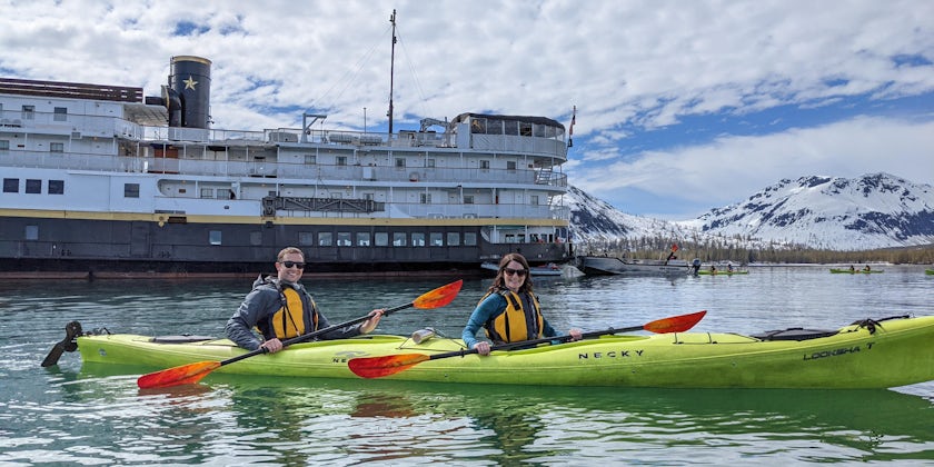 Couple in kayak in Alaska in front of Wilderness Legacy by UnCruise Adventures (Photo: Colleen McDaniel)