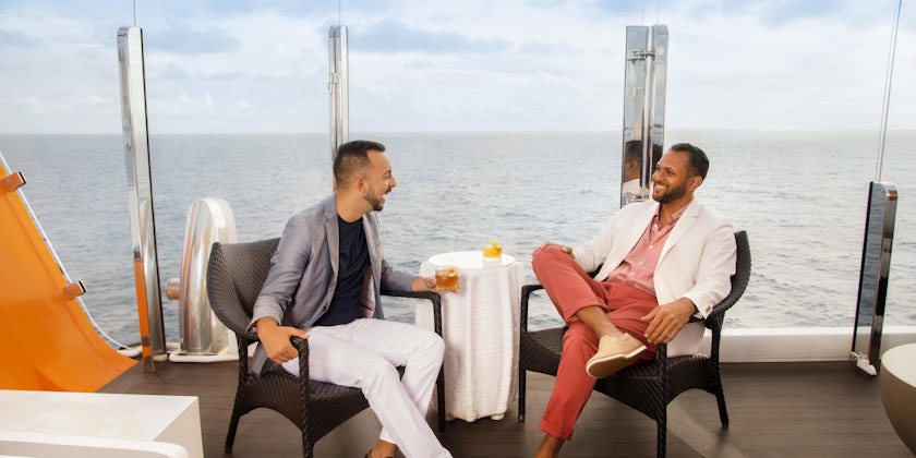 Carlos Martinez and Joel Vazquez relax with drinks on the Magic Carpet on Celebrity Edge. (Photo: Naima Green/AIPP)