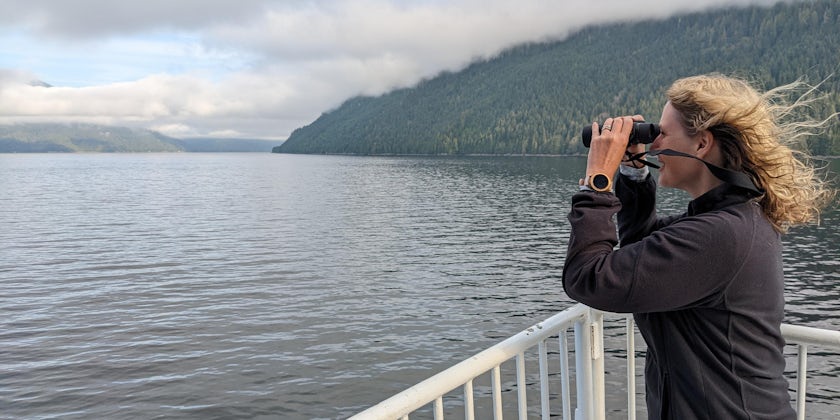 A woman uses binoculars to see the sights on a cruise to Alaska. (Photo: John Roberts)