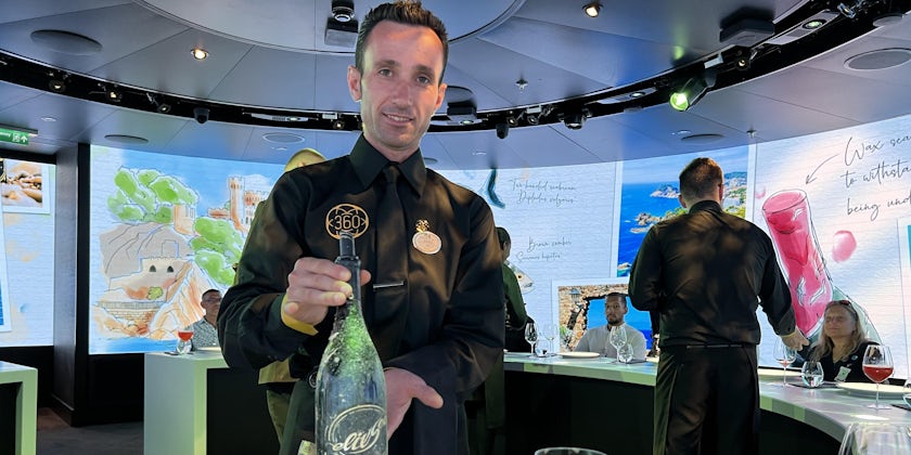 Waiter presents bottle of ElixSea wine at Enchanted Princess' 360: An Outstanding Experience restaurant (Photo: Jorge Oliver)
