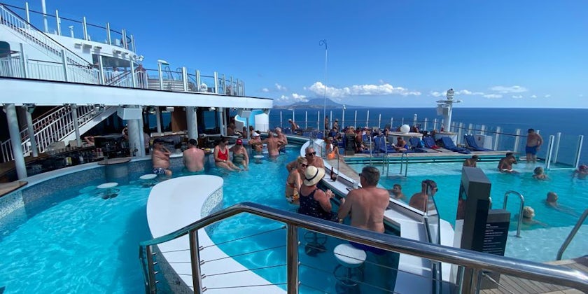 Guests enjoying cocktails at the swim up bar on P&O Cruises Arvia (Photo Jo Kessel)
