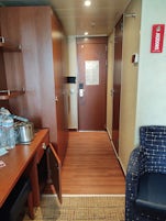 Showing dressing table/desk, chair and hallway door.  Bathroom door is on right, closets on left.
