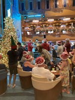 Christmas carols with free Carnival Santa hats in Atrium