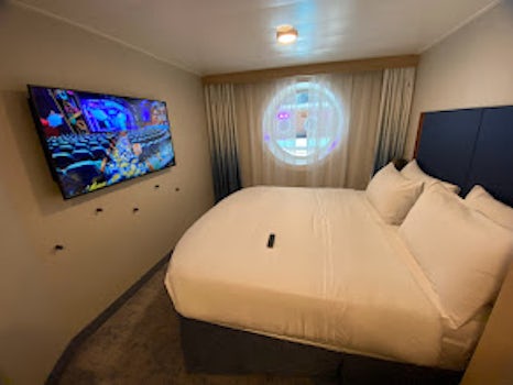 Picture of room facing towards bed and porthole.