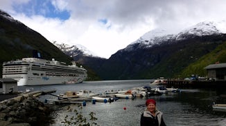 My "cool" wife on shore in Geiranger with the port, ship and tenders.