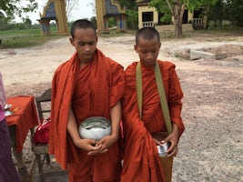 Monks on the side of the road with begging bowls