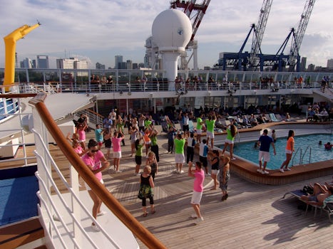 Sail away party with singing and dancing by production team and crew on pool deck