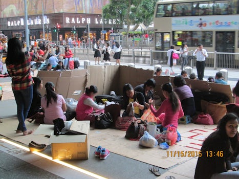 Sunday in Hong Kong the Filipino workers have their only day off and they meet at banks and public buildings around Hong Kong, make meeting areas with their friends out of carbord boxes to sit, chat and enjoy a meal and games.