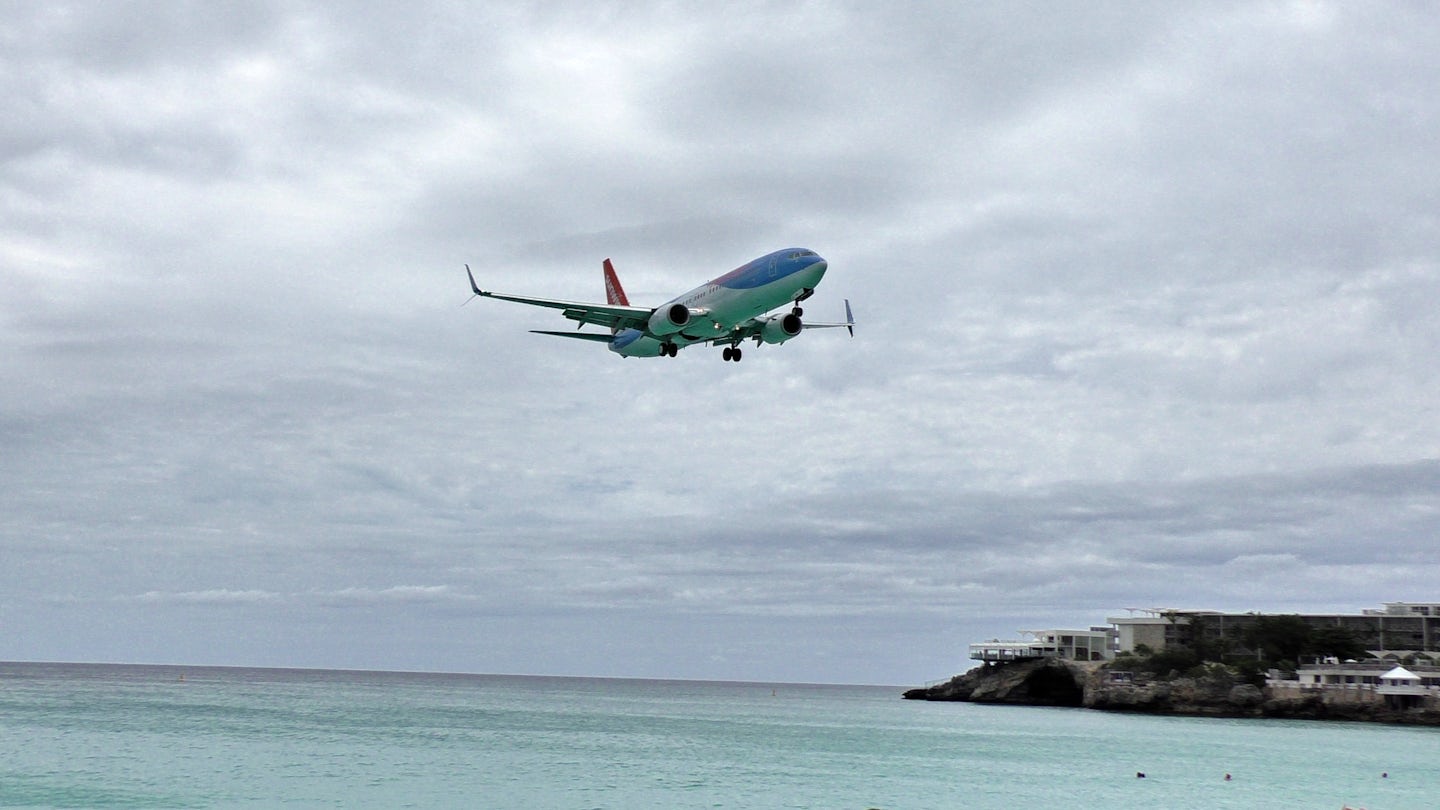 A plane coming in over Maho.