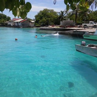 I shot this photo at a small port on the north side of Rangiroa. The photo was of children playing off the dock but the boat appear to be levitating!   The water is THAT clear!