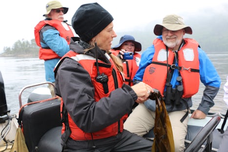 Expedition leader Pam with adventurers on a Zodiak, describing the wonders of kelp.