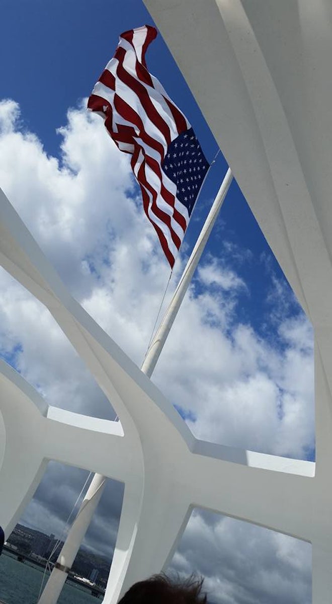 Flag at half staff through the USS Arizona Memorial roof