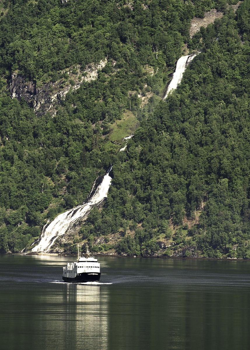 Geirangerfjord.  Another ship passes one of many waterfalls in the fjord