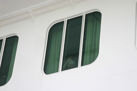 Mom waving at me from window on deck 6 of Escape at Tortola as I was return