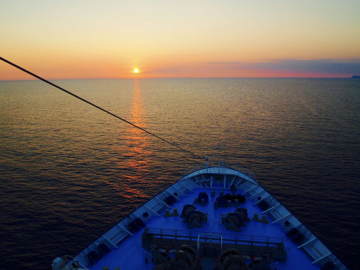 Sunset beyond the bow of TUI Discovery.