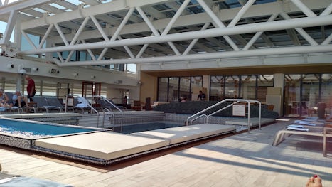pool in middle of ship with retractable roof. comfortable lounge chairs fac
