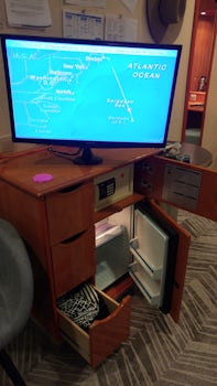 TV anchored on the dresser which houses 3 small drawers, the safe and the m