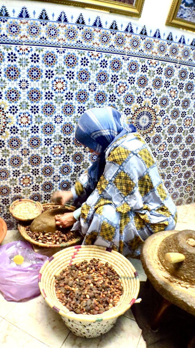 A lady in the souk breaking the Argan nuts.