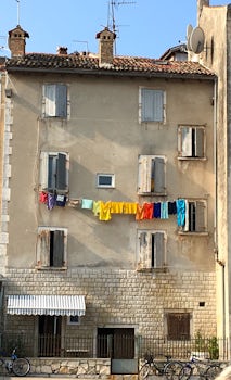 Colorful laundry line hanging from a line outside the 2nd story window.