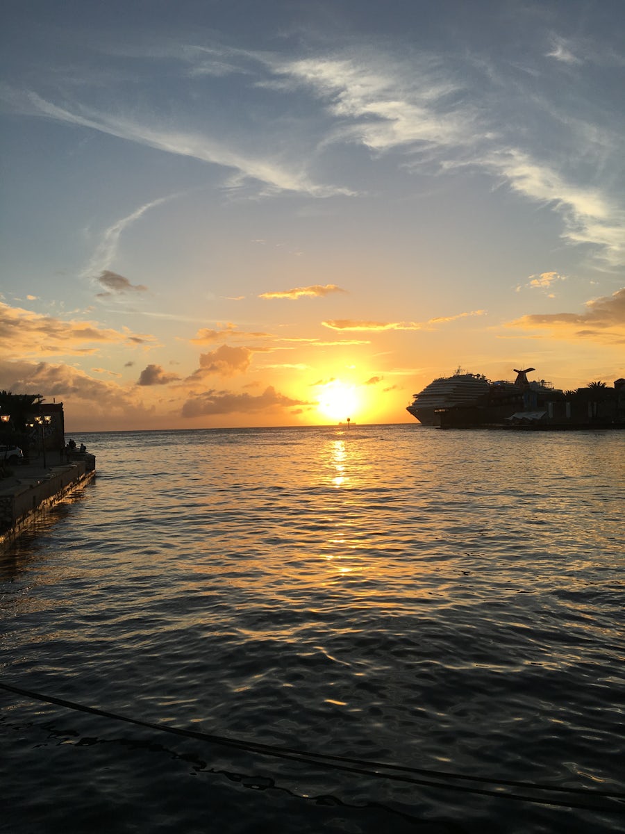 The sun is setting as Carnival Vista ports in Curaçao.