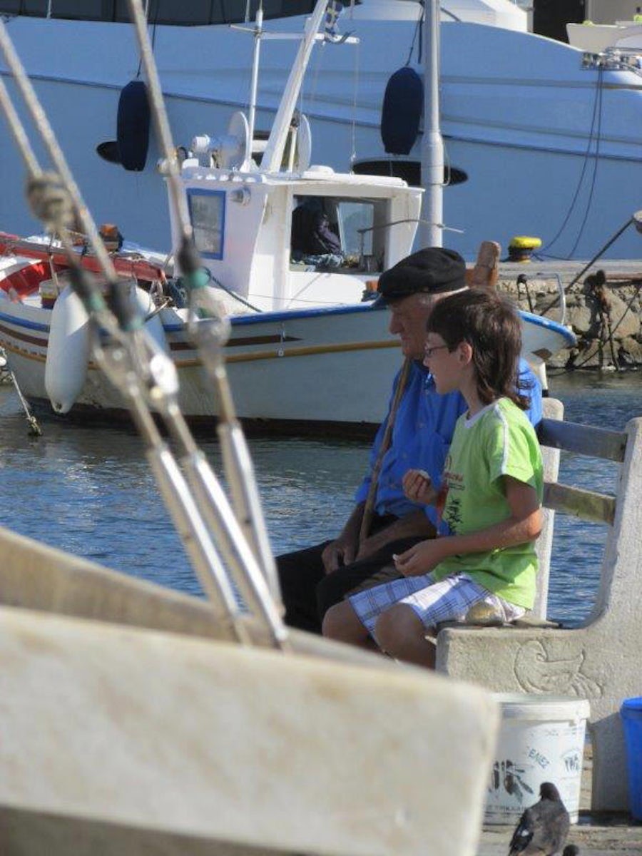Young boy and his Grandpa sitting at the harbor in Mykonos, Greece
Even though there were  tourists everywhere, these two found their quiet spot to chat. The ever friendly atmosphere of the Greek Islands is what made my cruise dream come true.