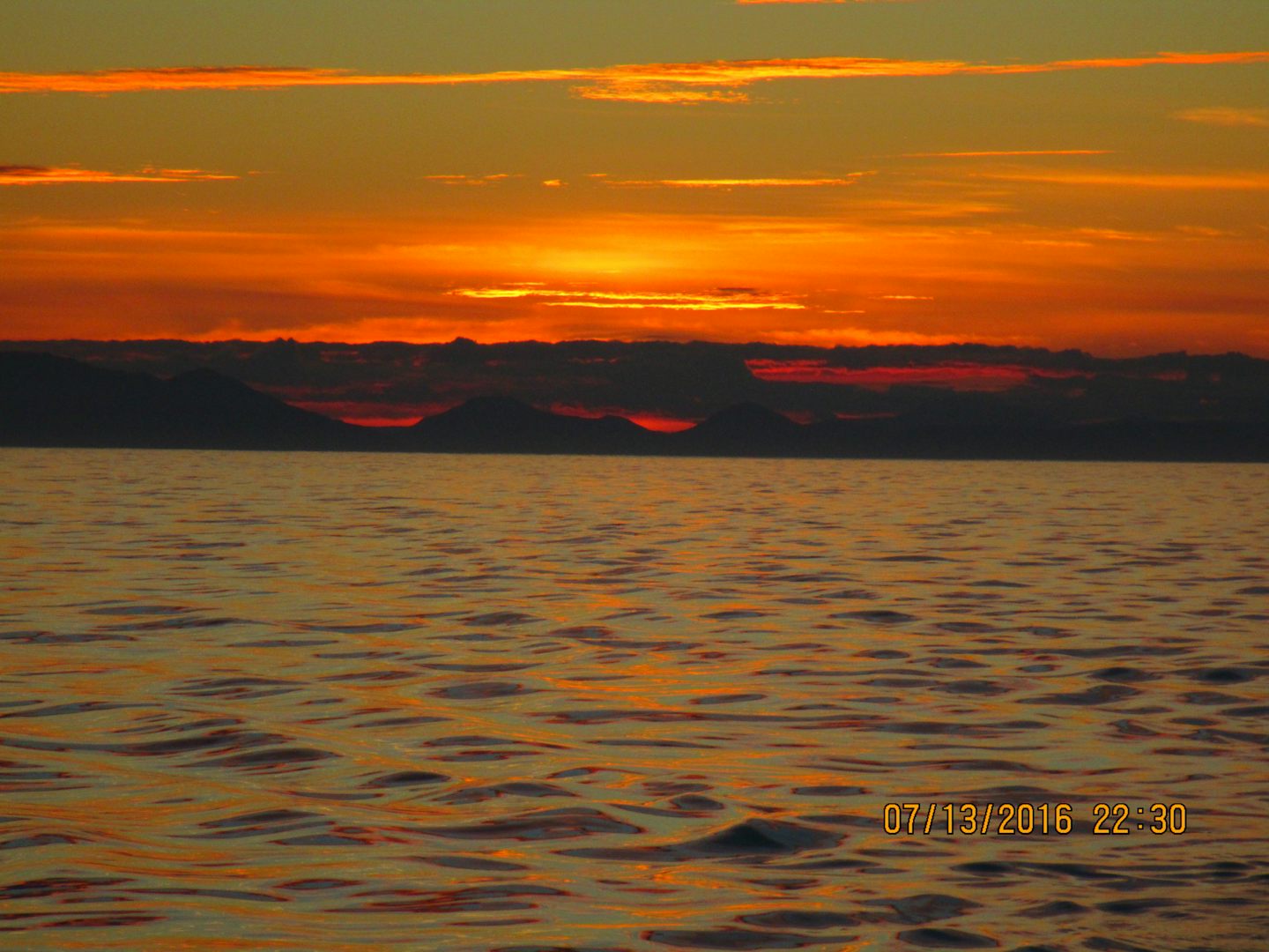 The quiet calm seas of the Alaskan Inside Passage highlighted by a beautiful sunset