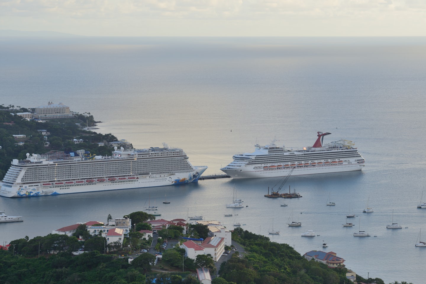Carnival Sunshine is dwarfed by Norwegian Escape at anchor in St. Thomas, U.S. Virgin Islands.