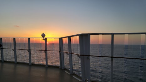 Last night of the cruise, sunset over the railing.