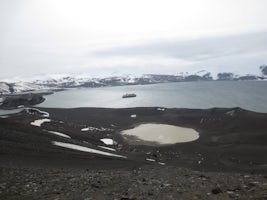 At the top of the volcano crater on Deception Island. Midnatsol in the bay.