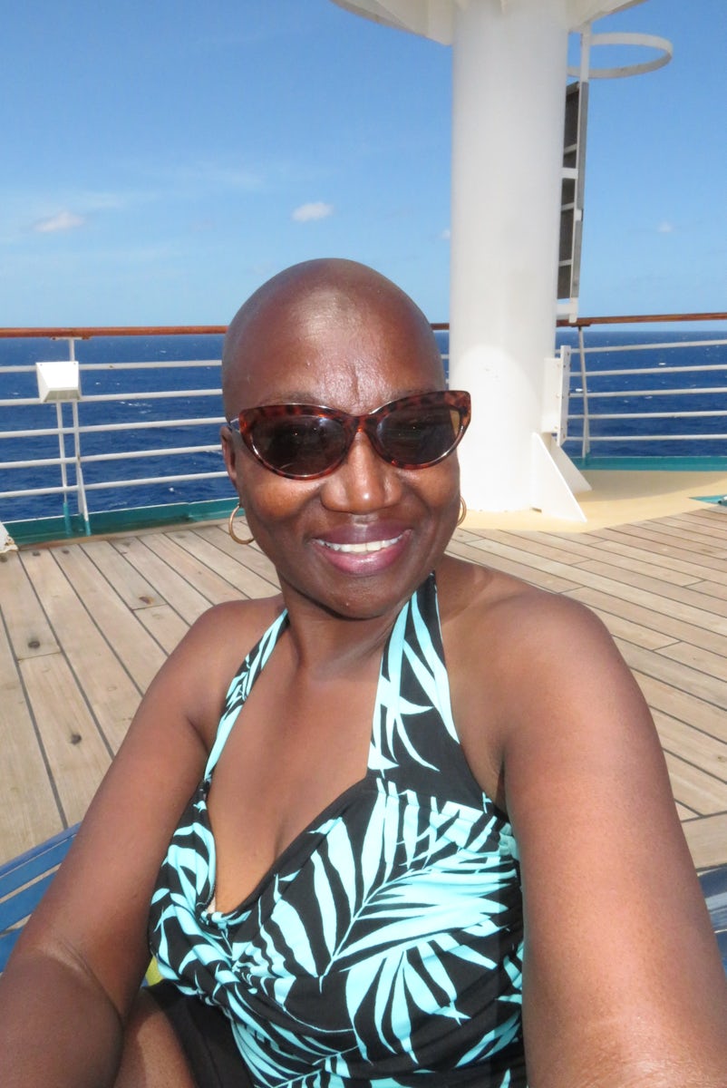 Author sitting on deck of "Enchantment of the Seas" enjoying the oc